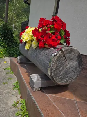 a wooden planter with red and yellow flowers in it at Apartment in the heart of nature in Bohinj