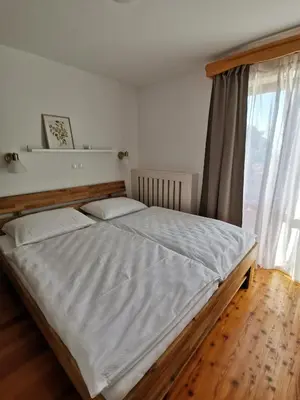 a large bed in a bedroom with a window at Apartma Lesjak - pobeg v naravo in Mozirje