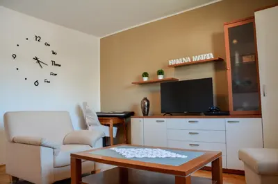 a living room with a chair and a table and a tv at House Marin - whole house in Maribor