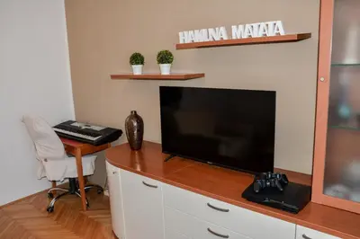 a living room with a television and a desk with a chair at House Marin - whole house in Maribor