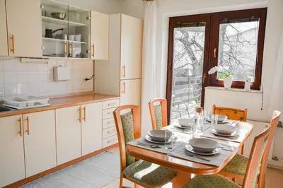a kitchen with a wooden table with chairs and a dining room at House Marin - whole house in Maribor