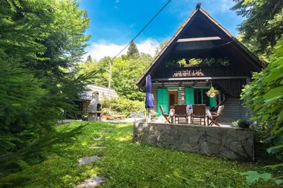 a cottage in the woods with two chairs at Vila Fani, Kostel - vacation house Pr' Vili Fani in Kostel