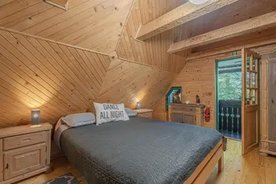 a bedroom with a bed in a wooden cabin at Vila Fani, Kostel - vacation house Pr' Vili Fani in Kostel