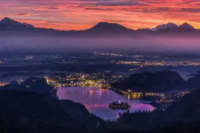 a view of a city and a lake at sunset at Apartment Mavrica Bled, quiet location, with a view of the lake in Bled