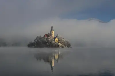 an island with a church in the middle of a lake at Apartment Mavrica Bled, quiet location, with a view of the lake in Bled