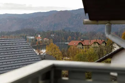 a view from a balcony of a house and a lake at Apartment Mavrica Bled, quiet location, with a view of the lake in Bled