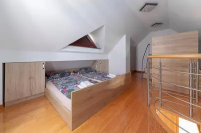 a bedroom with a bed in the middle of a room at Timber Apartment in Bohinj