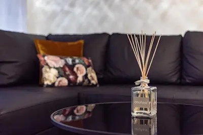 a glass bottle on a coffee table next to a couch at Bella Mura Golden Apartment in Moravske Toplice