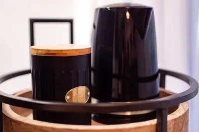 a black coffee mug sitting on top of a barrel at Bella Mura Golden Apartment in Moravske Toplice