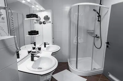 a white bathroom with two sinks and a shower at Bella Mura Golden Apartment in Moravske Toplice