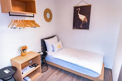 a small room with a bed and a small cabinet at Bella Mura Golden Apartment in Moravske Toplice