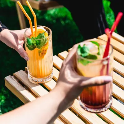 two hands holding two drinks on a table at B&B La Siesta in Markovci
