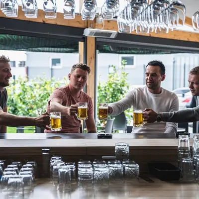 a group of men drinking beer at a bar at B&B La Siesta in Markovci