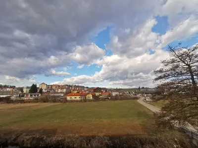 a green field with a town in the background at Roof Apartment ART-PE in Trebnje