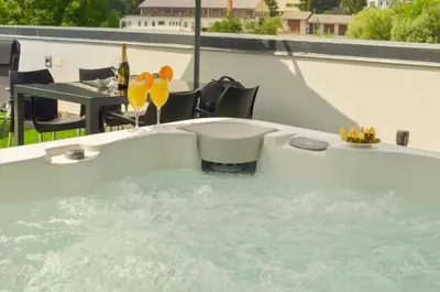 a jacuzzi tub with a table and some drinks in it at Roof Apartment ART-PE in Trebnje