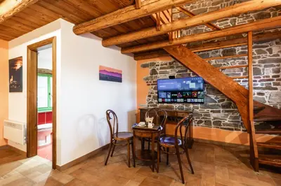 a dining room with a stone wall and a table and chairs at House Marica in Šmartno