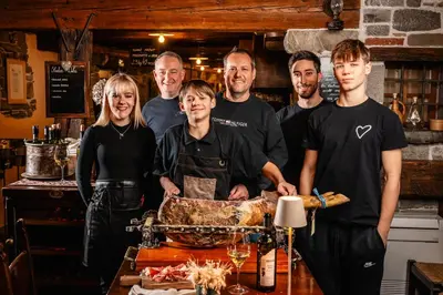 a group of people standing around a table in a kitchen at House Marica in Šmartno