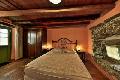 a bedroom with a large bed and a stone fireplace at House Marica in Šmartno