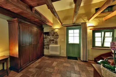a living room with a fireplace and a stone wall at House Marica in Šmartno
