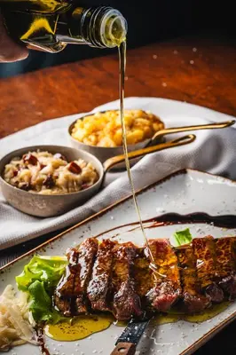 a plate of meat with sauce being poured onto it at House Marica in Šmartno