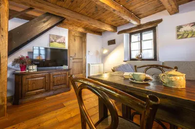 a dining room with a wooden table and a television at House Marica in Šmartno