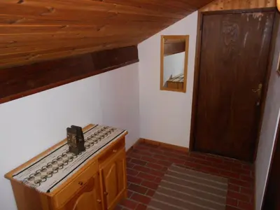 a small kitchen with a stove and a wooden door at Apartments Balon in Kranjska Gora