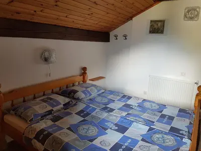 a bedroom with a bed with a blue and white quilt at Apartments Balon in Kranjska Gora