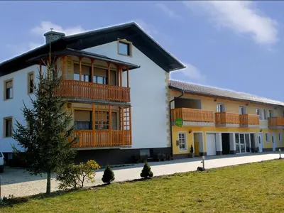 a large white building with wooden balconies on it at Tourist Farm Šalamun in Banovci