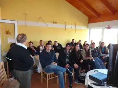 a man talking to a group of people in a room at Tourist Farm Šalamun in Banovci