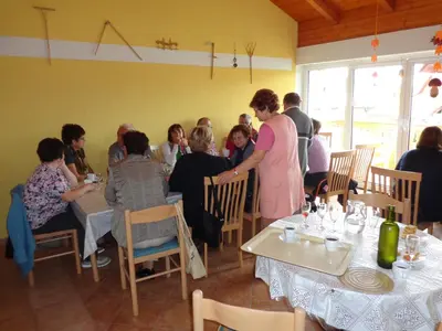 a group of people sitting at tables in a restaurant at Tourist Farm Šalamun in Banovci