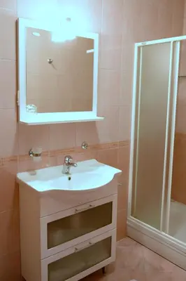 a bathroom with a sink and a shower with a mirror at Penzion Letališče in Murska Sobota