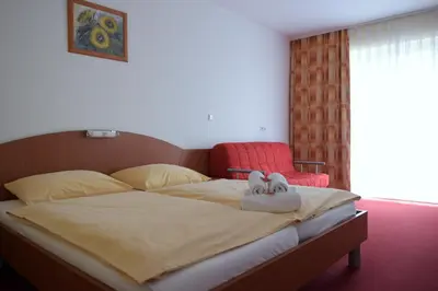 a bedroom with a bed with two stuffed animals on it at Penzion Letališče in Murska Sobota