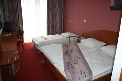 two twin beds in a room with red walls at Penzion Letališče in Murska Sobota