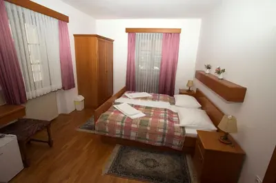 a small bedroom with a bed and a window at Guesthouse Špenko in Kamnik