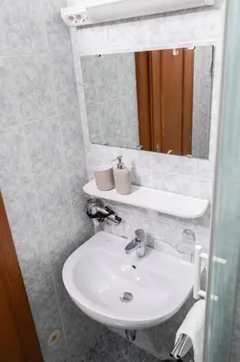 a bathroom with a sink and a mirror at Guesthouse Špenko in Kamnik