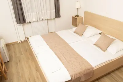 a large bed with white sheets and pillows in a room at Guesthouse Špenko in Kamnik