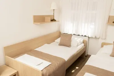 a small room with two beds and a window at Guesthouse Špenko in Kamnik