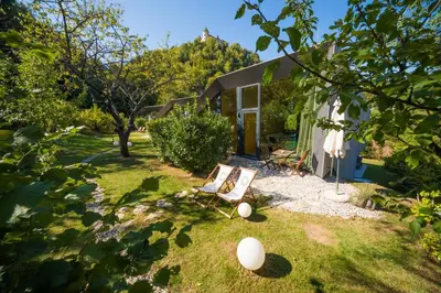 a yard with a chair and a house at Ortenia Apartments in Nature in Podčetrtek