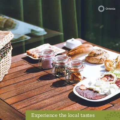 a wooden table with a plate of food on it at Ortenia Apartments in Nature in Podčetrtek