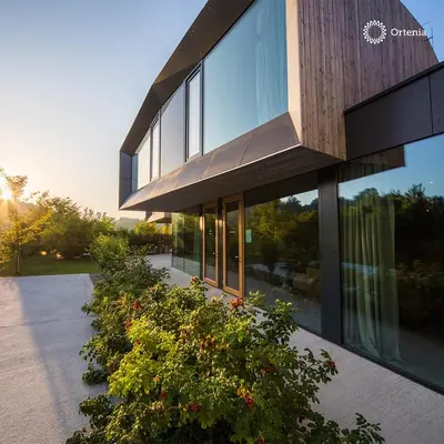 a building with glass windows on the side of it at Ortenia Apartments in Nature in Podčetrtek