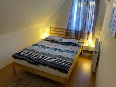 a small bed in a room with a window at Martinov dom in Kranjska Gora