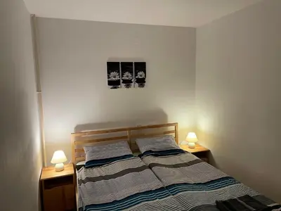 a bedroom with a bed with two lamps on both sides at Martinov dom in Kranjska Gora
