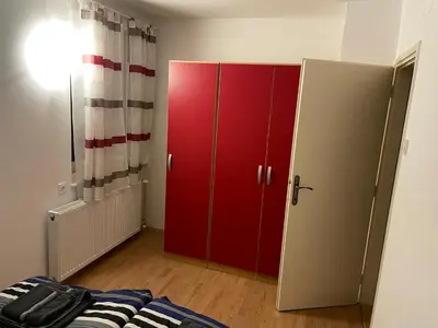 a bedroom with a red cabinet and a bed at Martinov dom in Kranjska Gora