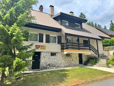 a large house with a stone wall at Martinov dom in Kranjska Gora