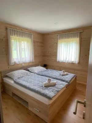 a bedroom with two beds with white towels on them at Martinova izba - Family Bungalows in Laško