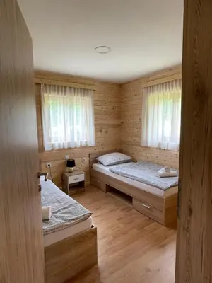 a room with two beds in a wooden cabin at Martinova izba - Family Bungalows in Laško
