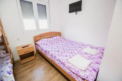 a small bedroom with a bed and a window at Rooms Vila Medena in Brežice