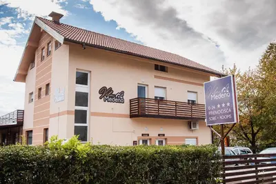 a building with a sign in front of it at Rooms Vila Medena in Brežice
