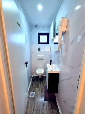 a white bathroom with a sink and a toilet at Hostel M in Maribor