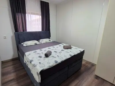 a small bedroom with a bed with a blue headboard at Hostel M in Maribor